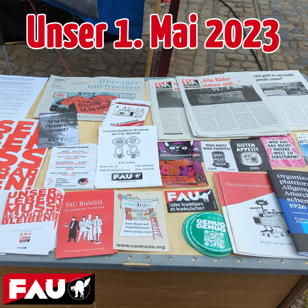 Ein Infostand voller Flyer und Sticker der FAU und befreundeter Organisationen wie Extinction Rebellion oder Genug ist Genug. Darüber steht "Unser 1. Mai 2023" und unten ist das Logo der FAU.